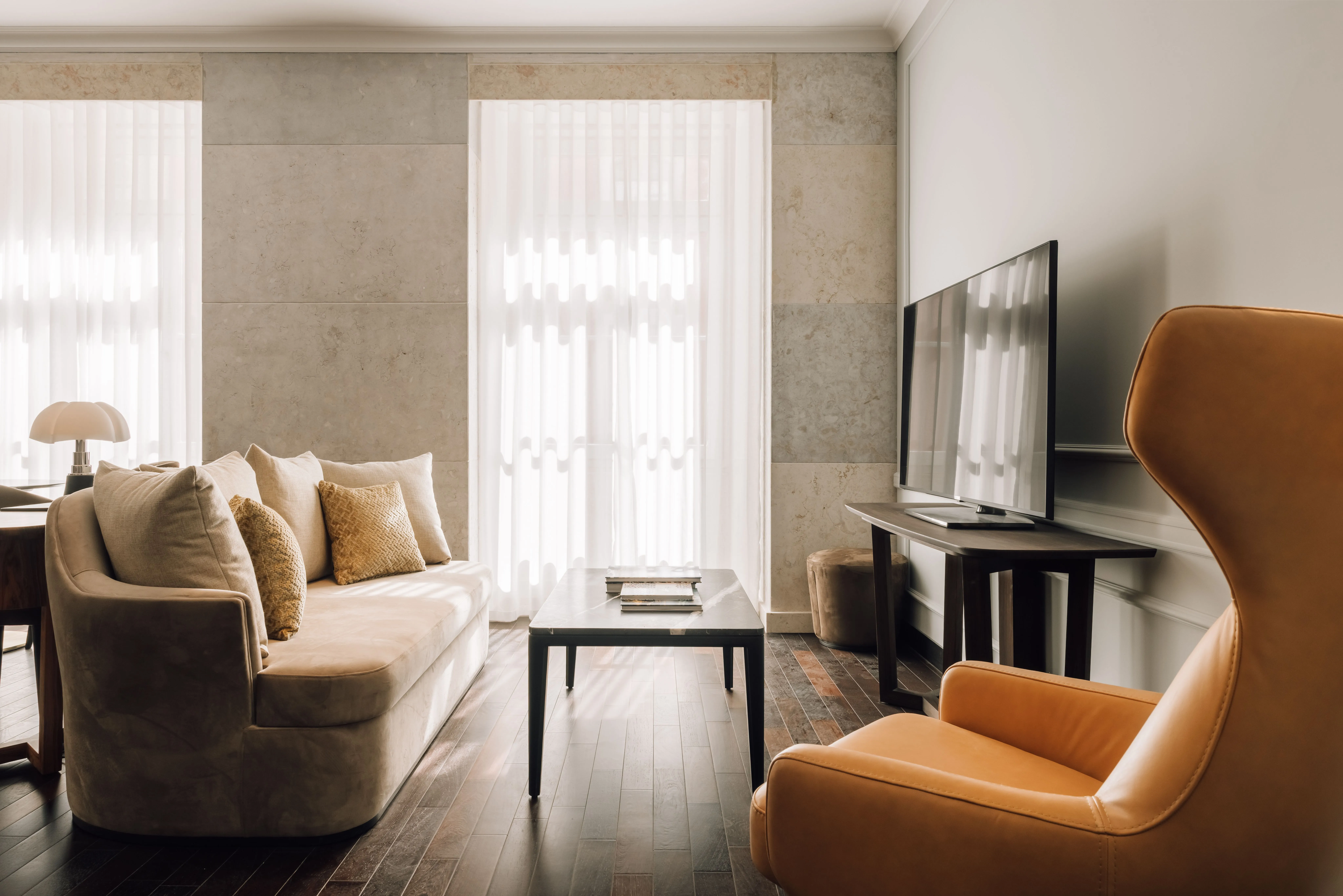Wohnbereich einer Suite mit cremefarbenem Sofa und Ohrensessel.